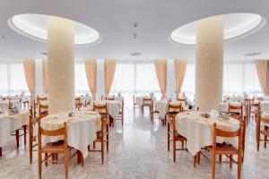 a dining room with tables and chairs with white tablecloths at Hotel Garden - Parking Included in Bellaria-Igea Marina