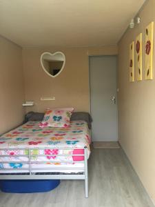 a bedroom with a bed and a heart shaped mirror at Jardin de Marceau in Blasimon