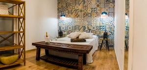 a room with a bed with a table and a wall at Jacaranda Apartments in Peñíscola