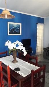 a dining room table with a vase of flowers on it at Apartamento no Varandas de Itaguá in Ubatuba