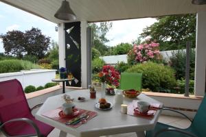 a white table and chairs on a patio with a view at Jardin de Marceau in Blasimon