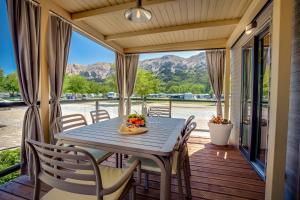 a table and chairs on a porch with a view of the mountains at Valamar Camping Baška in Baška