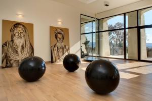 three black balls on a dance floor in a room with sculptures at Coquillade Provence - Relais & Châteaux in Gargas