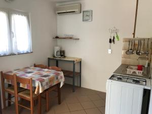 a small kitchen with a table and a stove at 35 meters from sea Apartment Keser and House for rent in Karlobag