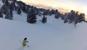 a person is skiing down a snow covered slope at Auberge Restaurant du Virage in Chamrousse