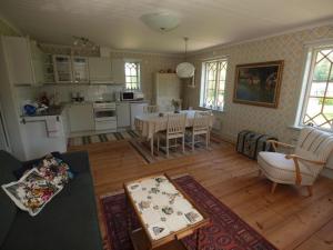 a living room with a table and a kitchen at Björka Storgård B&B in Motala