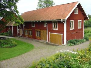 a red barn with yellow doors and a yard at Björka Storgård B&B in Motala