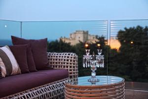 a glass table with a couch on a balcony with a castle at Rodos Park in Rhodes Town