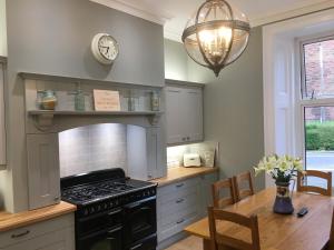a kitchen with a stove and a table and a clock at The Huntingdon in Dumfries