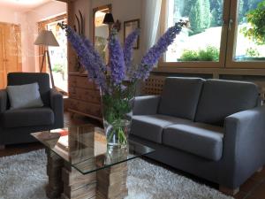 a living room with a vase of purple flowers on a table at Fedaia Joy B&B in Canazei