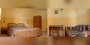 - une chambre avec deux lits, une table et une chaise dans l'établissement Affittacamere La Madonnina, à San Giovanni Rotondo