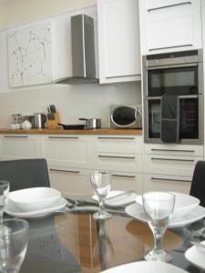 a kitchen with a table with plates and glasses on it at High Street Suites 3 in Ventnor