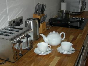 a kitchen counter with two cups and a toaster at High Street Suites 3 in Ventnor