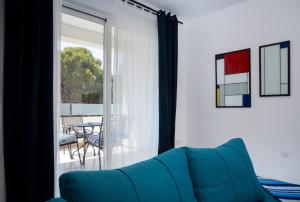 a living room with a blue couch in front of a sliding glass door at Apartments Tamburini in Rovinj