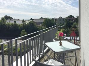 a table with a vase of flowers on a balcony at Ferienwohnung *Richi* in Sassnitz