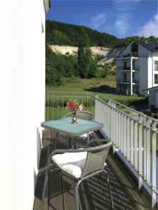 una mesa en un balcón con un jarrón de flores en Ferienwohnung *Richi*, en Sassnitz