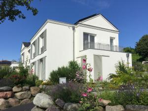 a white house with a garden in front of it at Ferienwohnung *Richi* in Sassnitz