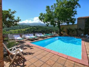 a swimming pool with chaise lounges and chairs at Ca' De' Principi - Residenza D'epoca in Piegaro
