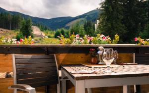 a wooden table with a glass of wine on a balcony at Hotel Liptov in Belá