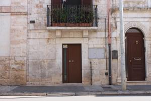 トゥーリにあるB&B Celliniの茶色のドア2つとバルコニー付きの建物