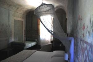 een slaapkamer met een bed en een raam met een gordijn bij antica casa "le rondini" in Borgo a Buggiano