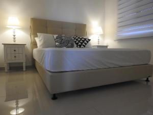 a bedroom with a bed with two lamps and a window at ERA home boutique in Eilat