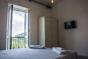 a bedroom with a bed with two towels on it at Apartment Sotto Il Santo in Orco Feglino