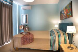 a bedroom with a bed in a blue room at Stella in the Village Suites in Plakias +50 photos