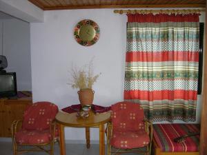 a room with a table and two chairs and a mirror at Kyra's Paradise in Potistika