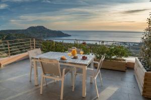 stół i krzesła na balkonie z widokiem na ocean w obiekcie Stella in the Village Suites w mieście Plakias
