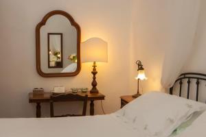a bedroom with a bed and a table with a mirror at Masseria Il Frantoio in Ostuni