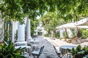 a patio with tables and chairs and umbrellas at Masseria Il Frantoio in Ostuni