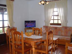 a dining room with a table and chairs and a couch at Casa Los Viñedos B in Fuencaliente de la Palma