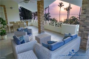 a patio with wicker chairs and a view of the ocean at Hotel Residence Marilar in Las Terrenas