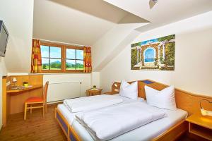 a bedroom with a large bed with a desk and a desk at Landhotel Wiesbauer in Füssen