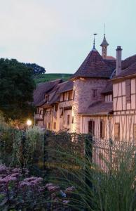 a group of buildings with a fence in a garden at Les Appartements De Louise in Riquewihr