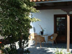 un patio avec une table et des chaises à côté d'un bâtiment dans l'établissement Casa Los Viñedos B, à Fuencaliente de la Palma