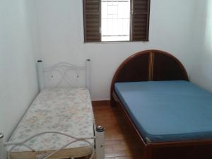 1 dormitorio con 2 camas y ventana en Casa em Caraguatatuba en Caraguatatuba