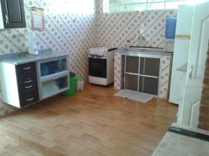 eine Küche mit einem Herd und einem Waschbecken in einem Zimmer in der Unterkunft Casa em Caraguatatuba in Caraguatatuba