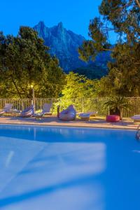 einen Pool mit Liegestühlen und einem Berg in der Unterkunft Capo D'orto - Porto - Corse in Porto Ota