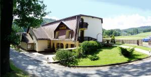 ein Haus auf einer Straße mit einem grünen Hof in der Unterkunft Penzion Vaněk in Velké Losiny