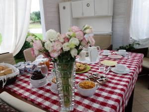 a table with a vase of flowers and food on it at IL PRINCIPINO B&B in Massa