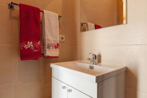 a bathroom with a sink and a mirror and towels at Casa da Lagiela rural senses in Fafe +92 photos