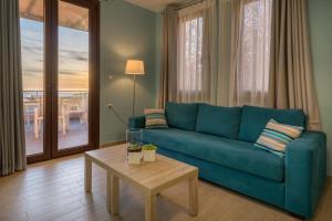 a living room with a blue couch and a table at Stella in the Village Suites in Plakias