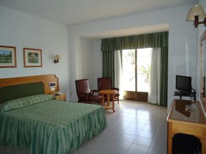 um quarto de hotel com uma cama e uma televisão em Hotel las Conchas em La Rábita