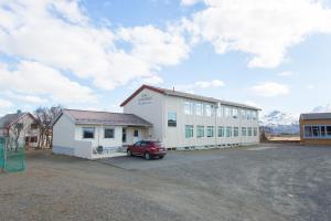 a building with a car parked in a parking lot at Lofotr Overnatting in B&oslash;stad