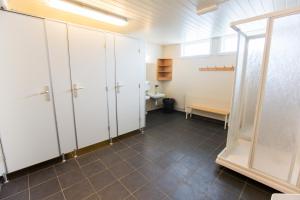 a bathroom with white cabinets and a toilet in a room at Lofotr Overnatting in B&oslash;stad