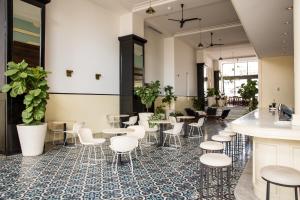 a lobby with tables and chairs and plants at American Trade Hotel in Panama City