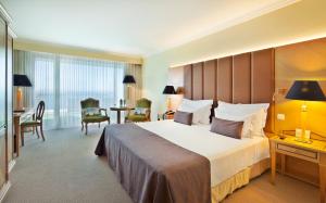 a hotel room with a large bed and a desk at Hotel Cascais Miragem Health & Spa in Cascais