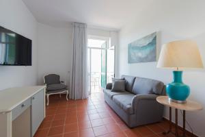 a living room with a couch and a table with a lamp at Santa Clara Country Hotel in Santa Clara-a-Velha